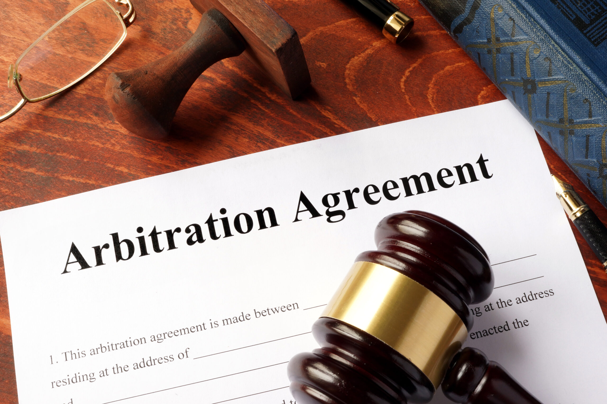 Arbitration agreement form on an office table. golden-icon-with-scales-of-justice-and-text-legal-concept